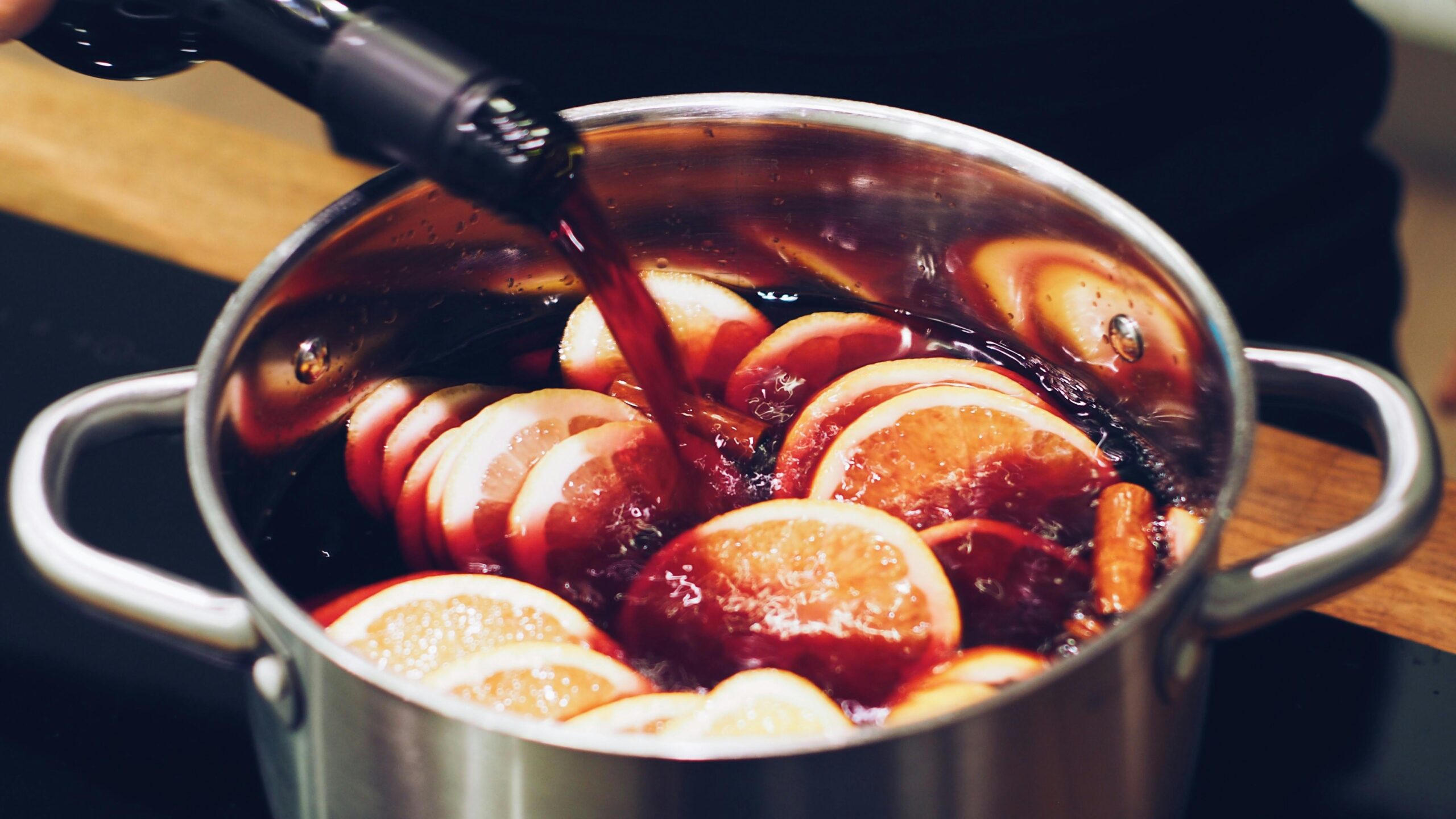 Close-up of mulled wine being prepared with citrus slices and spices. Perfect for festive moments.